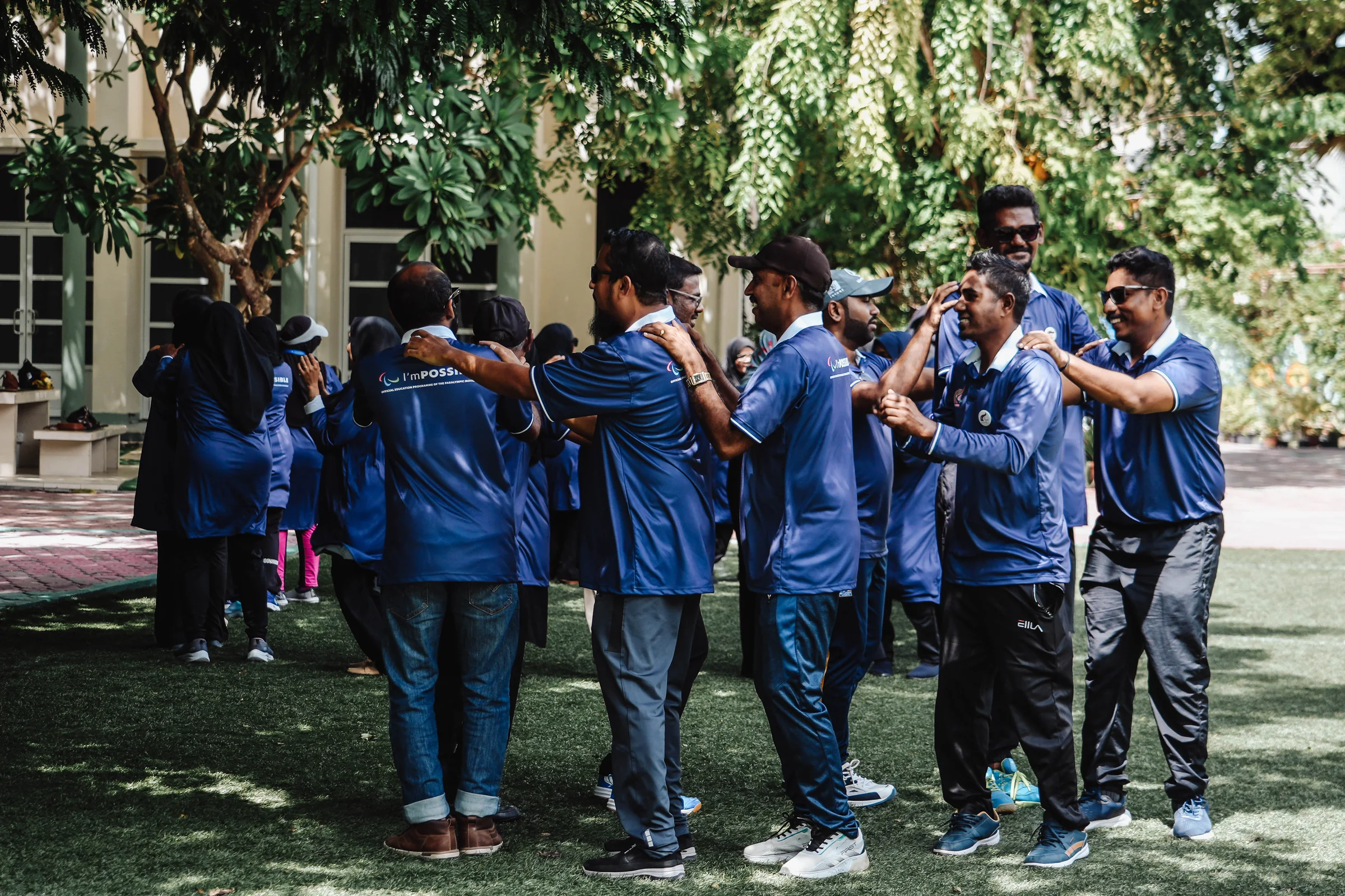 Participants smile as they move through a linked outdoor team-building exercise.